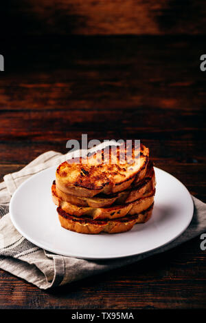 French toasts on white plate over wooden surface Stock Photo