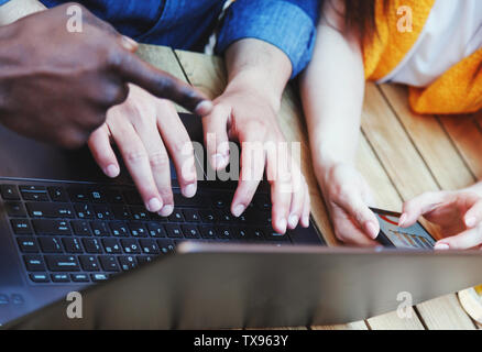 Close up view of three multicultural smart students preparing homework tasks at the outdoor cafe Stock Photo