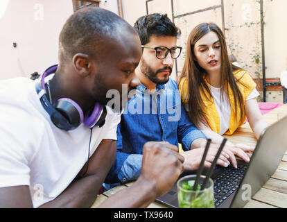 Three multicultural smart students studying at the open air Stock Photo