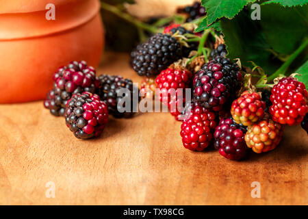 Beautiful fresh organic blackberries with leaf on wooden plate background Stock Photo