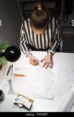 Top view of a young woman architect working over a new project at her workplace Stock Photo