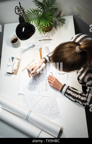 Top view of a young woman architect working over a new project at her workplace Stock Photo