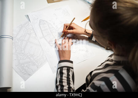 Top view of a young woman architect working over a new project at her workplace Stock Photo