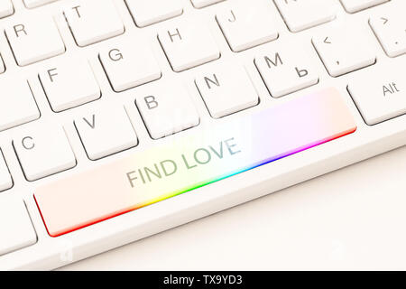 Homosexual online dating concept. White keyboard with rainbow button and an inscription find love. Close-up view Stock Photo