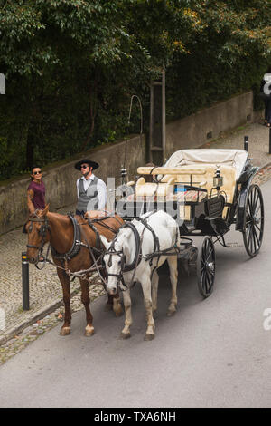 Tourist horse and carriage ride waiting in R. Barbosa du Bocage outside the UNESCO World Heritage Site of The Quinta da Regaleira, Sintra, Portugal. Stock Photo