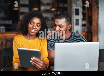 Young couple with laptop and digital tablet in café Stock Photo