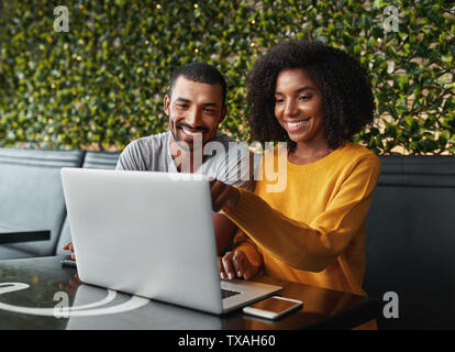 Young couple in café looking at laptop Stock Photo