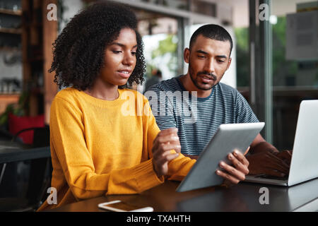 Young couple looking at digital tablet in cafe Stock Photo
