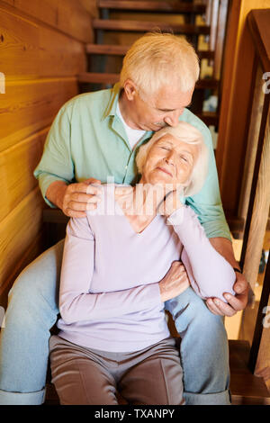 Senior man kissing his wife head and embracing her Stock Photo
