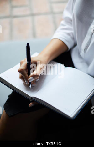 Closeup of unrecognizable businesswoman writing on blank paper in planner, copy space Stock Photo