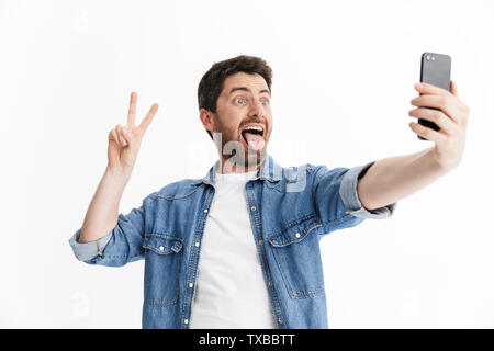 Portrait of a handsome bearded man wearing casual clothes standing isolated over white background, taking a selfie Stock Photo