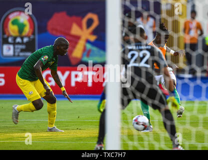 Cairo, Egypt. 24th June, 2019. Dazet Wilfried Armel Zaha (R) of Cote d'Ivoire shoots during the 2019 Africa Cup of Nations Group D match between Cote d'Ivoire and South Africa in Cairo, Egypt, on June 24, 2019. Cote d'Ivoire won 1-0. Credit: Li Yan/Xinhua/Alamy Live News Stock Photo