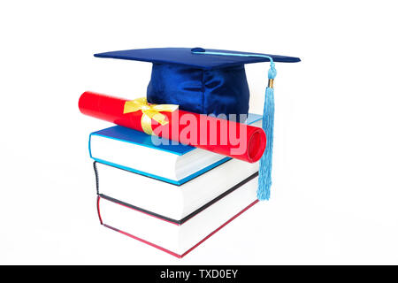 Blue graduation cap with diploma in case on top of books isolated on white background. Education concept. Stock Photo