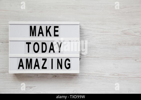 'Make today amazing' words on a modern board on a white wooden surface. From above, overhead, flat lay, top view. Copy space. Stock Photo