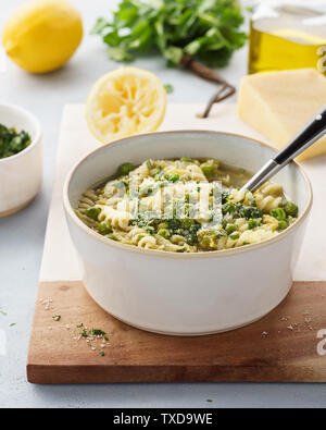 Minestrone, Italian vegetable soup with pasta and savoy cabbage. Served with cilantro pesto and parmesan. Healthy vegetarian food. Stock Photo