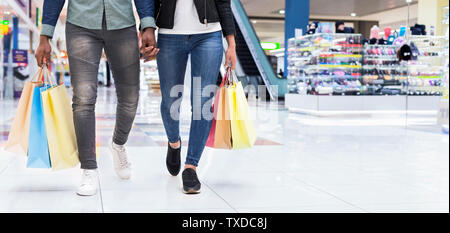 Sales and shopping concept, black couple with shopping bags at mall background, copy space, crop Stock Photo