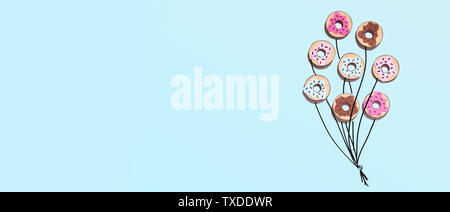 Creative food minimalism. Donuts in shape of balloons on blue summer background, panorama, copy space Stock Photo