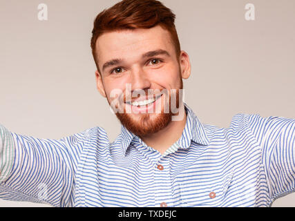 Handsome millennial guy making selfie and smiling on studio background, panorama Stock Photo