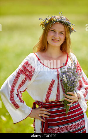 Romanian girl in traditional costume in a field Stock Photo