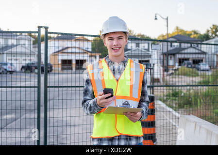 Happy construction foreman talking with an employee on his cell phone. Stock Photo