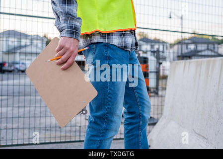 Construction worker holding a clip board close up. Stock Photo