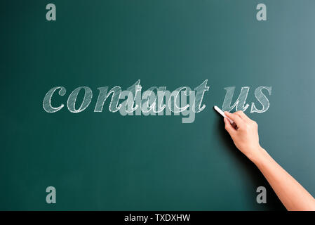 Contact us written on blackboard q Stock Photo