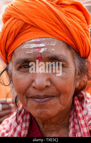 Portrait of a Sadhvi in orange red saree during Allahabad Kumbh Mela, For editorial use only, World’s largest religious gathering, Uttar Pradesh, Indi Stock Photo