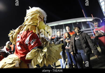 Atlanta Falcons fans pose for photos with team mascot Freddie the Falcon prior to their night NFL football game with the New Orleans Saints at the Georgia Dome in Atlanta on November 29, 2012.     UPI/David Tulis Stock Photo