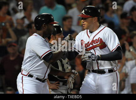 The Atlanta Braves' Chipper Jones is congratulated by teammate Freddie  Freeman (5) after his solo home run in the second inning against the Los  Angeles Dodgers at Turner Field in Atlanta, Georgia