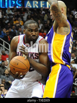 Atlanta Hawks' Elton Brand (L) is blocked by Los Angeles Lakers' Robert Sacre (R) in the second half of their NBA basketball game at Philips Arena in Atlanta, December 16, 2013. Atlanta won 114-100. UPI/David Tulis Stock Photo