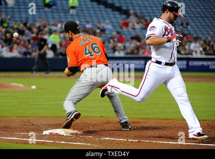 Atlanta Braves' Dan Uggla (R) beats out a grounder for a single in front of Miami Marlins first baseman Garrett Jones (46) in the second inning at Turner Field in Atlanta, April 21, 2013. UPI/David Tulis Stock Photo