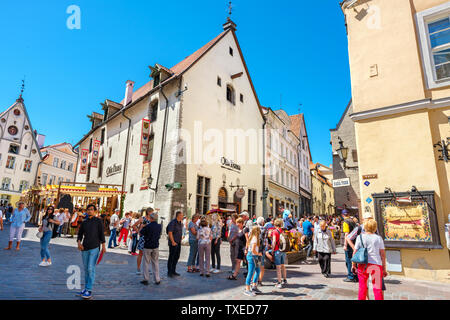 Tourists crowd on a street and sidewalk cafes in the medieval Old Market Square at historical town. Tallinn, Estonia Stock Photo