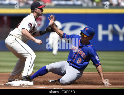 New York Mets' Matt den Dekker (6) safely slides into third base ahead of the throw to Atlanta Braves third baseman Chris Johnson (23) on a pop out by Wilmer Flores during the first inning at Turner Field in Atlanta, September 21, 2014. UPI/David Tulis Stock Photo