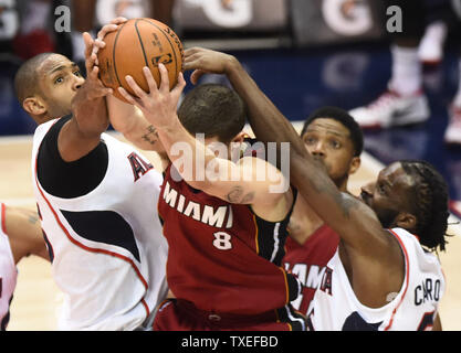 Miami Heat guard Tyler Johnson (8) is blocked by Atlanta Hawks' Al Horford (L) and DeMarre Carroll (R) during the first half of an NBA game at Philips Arena in Atlanta, March 27, 2015. Photo by David Tulis/UPI Stock Photo