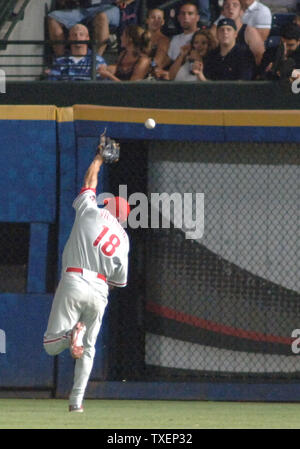 The Philadelphia Phillies' Shane Victorino (18) is safe at first as New  York Yankees first baseman Jason Giambi leaps but can't catch an overthrow  by second baseman Robinson Cano in the fourth