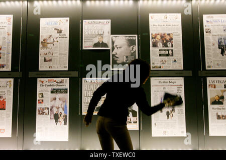 Dora Romero, 31, of Washington, DC cleans the display window at the Newseum in Washington on January 20, 2009, where front pages are displayed from yesterday's papers. Barack Obama is sworn in as the 44th President of the United States today.   (UPI Photo/Arianne Teeple) Stock Photo