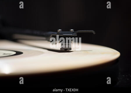 A vinyl record spinning on a black turntable Stock Photo