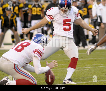 Place kicker Lawrence Tynes of the New York Giants kicks a field goal out  of the hold of punter Jeff Feagles while taking on the A…