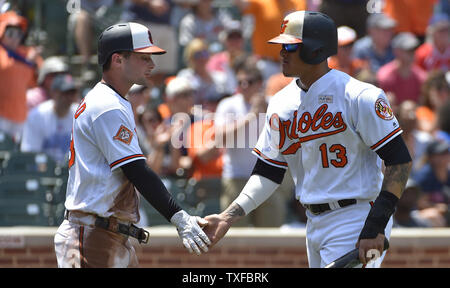 Baltimore Orioles' Adam Jones (L) and Manny Machado score against the Texas  Rangers on a double by Jonathan Schoop during the first inning at Camden  Yards in Baltimore, July 18, 2017. Photo