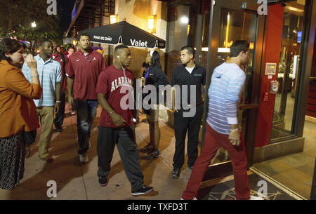 University of Alabama football team, along with players Adrian Hubbard (left),  Christion Jones, (center) follow quarterback AJ McCarron into the Fogo de Chao Restaurant for dinner in Miami Beach January 4, 2013 prior to their playing Notre Dame in  the BCS National Championship January 7, 2013.  UPI/Mark Wallheiser Stock Photo