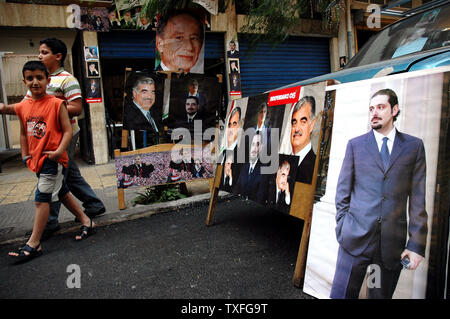 Lebanese kids walk past campaign posters for Saad Hariri, son of the popular slain ex PM Rafik Hariri, in Beirut the evening before parliamentary elections are due to take place on May 28, 2005. The elections will be the first in thirty years to be held without the presence of Syrian troops in Lebanon.  It is typical of Lebanese politics that a relative of a popular leader should ride the wave of popularity into public office. (UPI Photo/Stewart Innes) Stock Photo