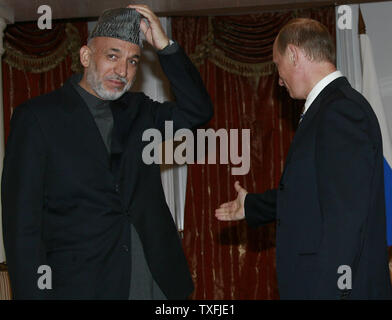 Russian President Vladimir Putin welcomes Afghan President Khamid Karzai before their tete-a-tete meeting during the Shanghai Cooperation Organization Summit in Bishkek on August 16, 2007. The leaders of Russia, China and four ex-Soviet Central Asian states said on Thursday energy cooperation was the key to the security in their resource-rich region, which they intend to uphold through common instruments. (UPI Photo/Anatoli Zhdanov) Stock Photo