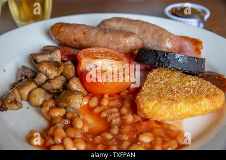 Traditional English breakfast with sausage, bacon, mushrooms, hash browns, tomato, black pudding but no egg Stock Photo