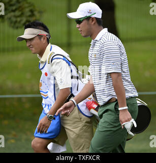 International Team member Hideki Matsuyama of Japan (R) and his caddie Daisuke Shindo walk up the sixth hole during the fourball matches at the 2013 Presidents Cup at Muirfield Village Golf Club in Dublin, Ohio on October 3, 2013.  UPI/Brian Kersey Stock Photo