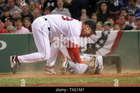 Boston Red Sox pitcher Tim Wakefield is late applying the tag to Tampa Bay Devil Rays first baseman Travis Lee as he scores in the second inning, putting the Devil Rays up 2-1 at Fenway Park in Boston on April 20, 2006. (UPI Photo / Katie McMahon) Stock Photo