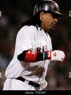 The Boston Red Sox cheer from home plate as runner Manny Ramirez (24) makes  his way towards them after Ramirez hit a game winning three run homerun in  the ninth inning of