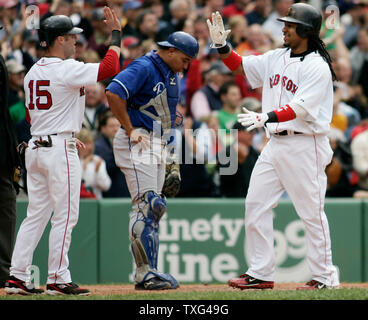Boston Red Sox's Dustin Pedroia (15) gives a high five to teammate Manny Ramirez after the two scored on a home run by teammate Mike Lowell (not pictured) in the sixth inning at Fenway Park in Boston, Massachusetts on May 22, 2008. Standing at home plate is Kansas City Royals catcher Miguel Olivo (21).  (UPI Photo/Matthew Healey) Stock Photo