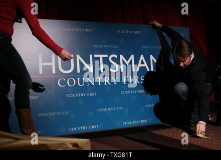 Workers set up a sign for republican presidential candidate Jon Huntsman before the start of his primary night party at The Black Brimmer Bar and Grill in Manchester, New Hampshire on primary election night on January 10, 2012.    UPI/Matthew Healey