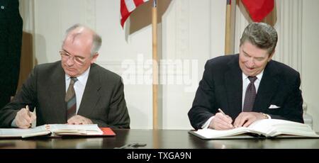 General Secretary Mikhail Gorbachev (left) and US President Ronald Reagan (right) sign the  Intermediate-Range Nuclear Forces Treaty (INF). Washington, White House, December 8, 1987 Stock Photo