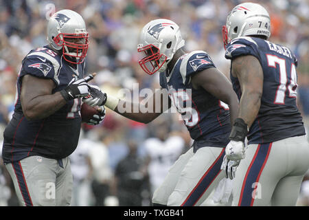 New England Patriots defensive tackle Vince Wilfork (L) is congratulated by  teammates defensive end Chandler Jones (C) and defensive lineman Dominique  Easley after intercepting a pass in the final minutes of the